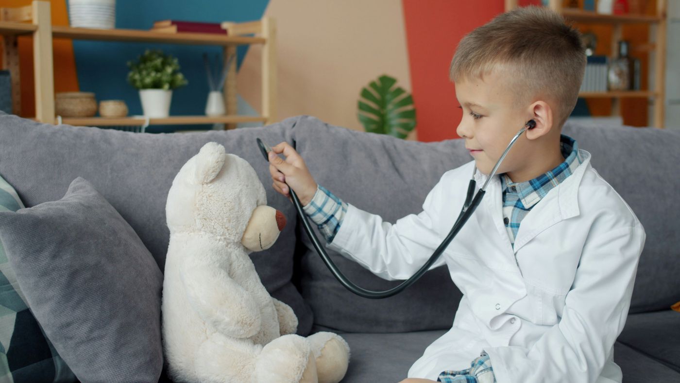 Child playing doctor with plush at the convenience of home